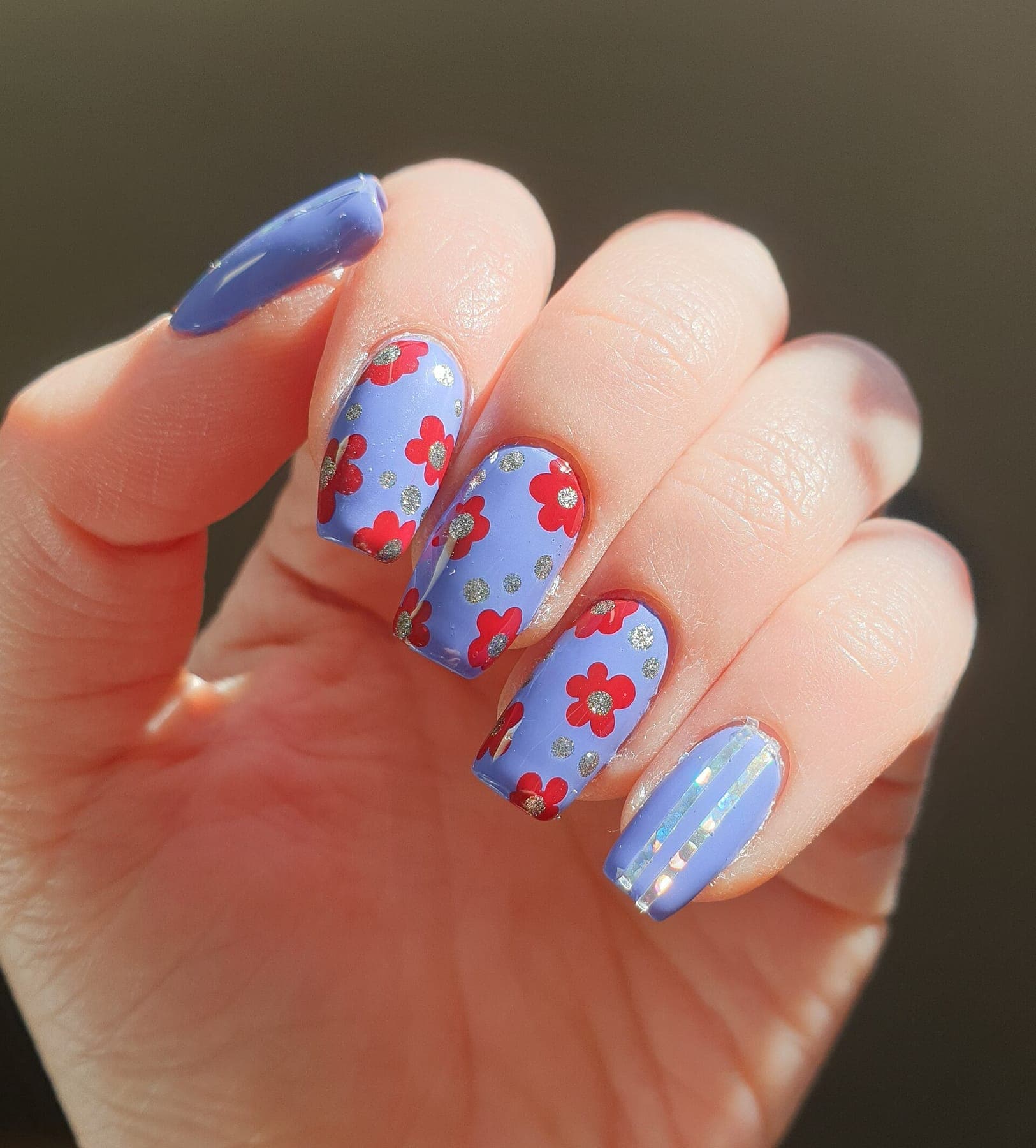 Periwinkle nails with hand-painted red flowers and silver glitter dots